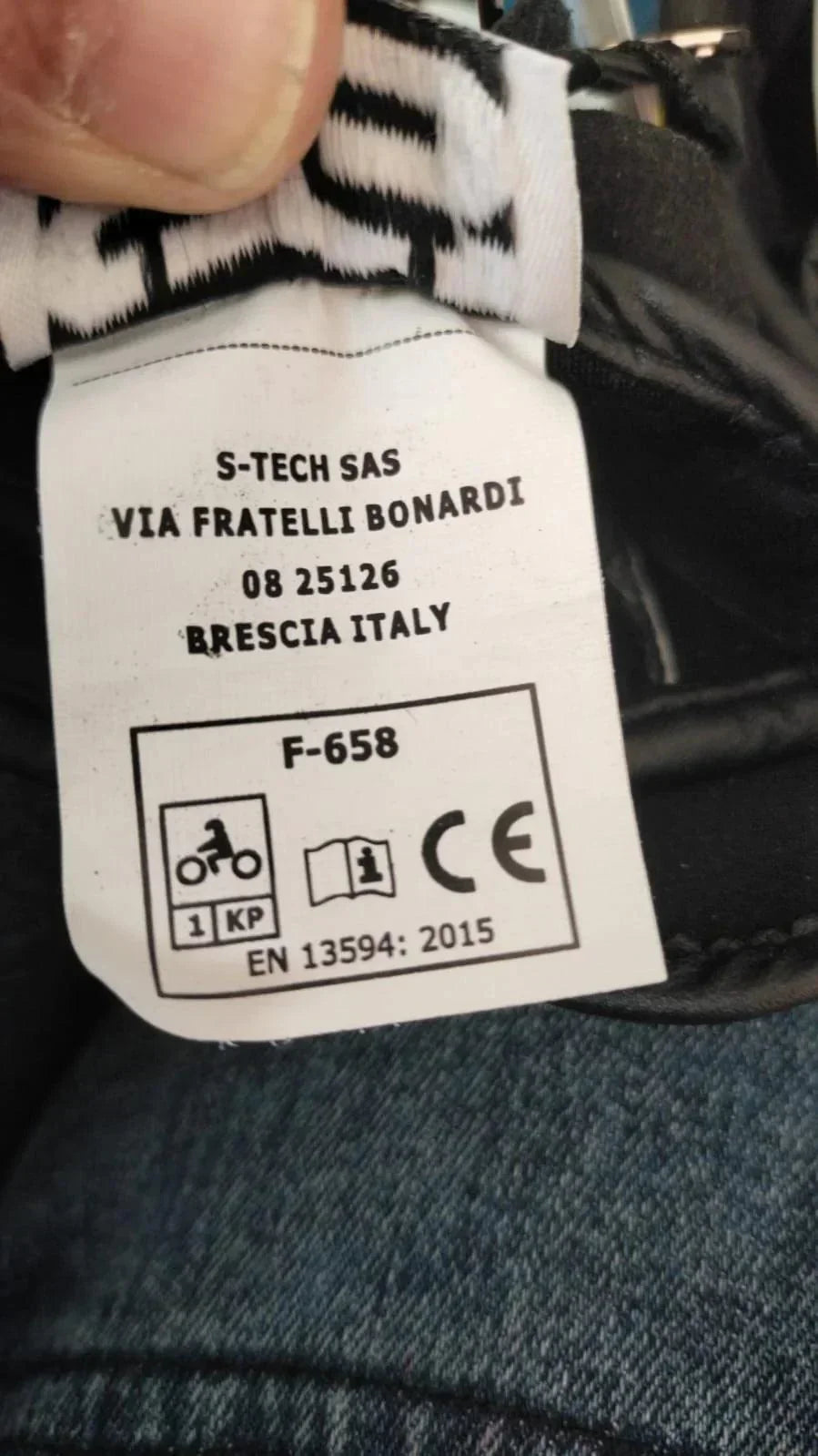 Etichetta interna di guanti moto in pelle, modello F-658, certificazione CE, dettaglio tessuto.